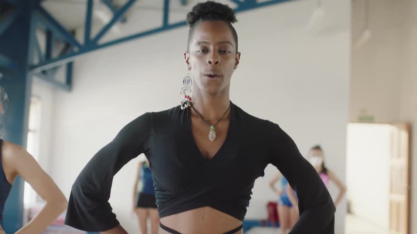 A woman is leading a group of dancers in a building
