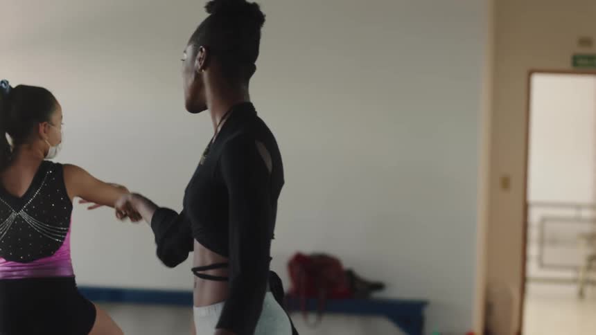 A woman instructs her students in a dance class