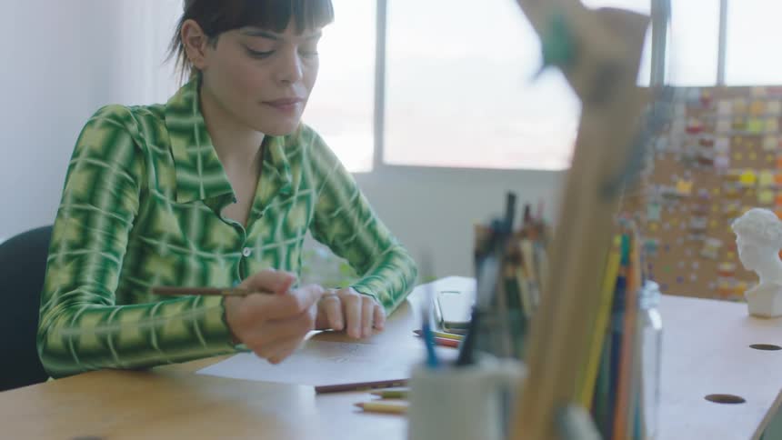 A young woman is drawing on a piece of paper
