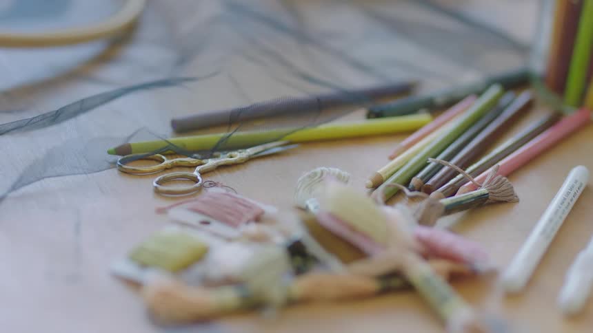 Pencils and yarn are set on a wooden table