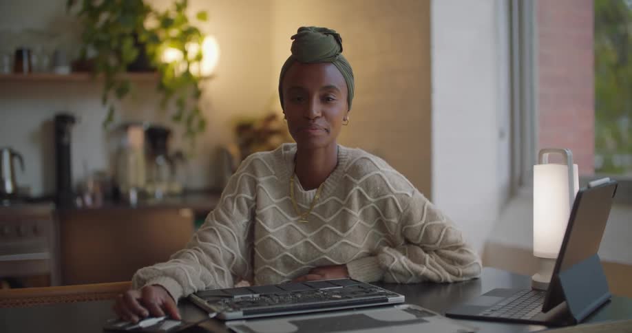 A woman is smiling and sitting at a computer desk