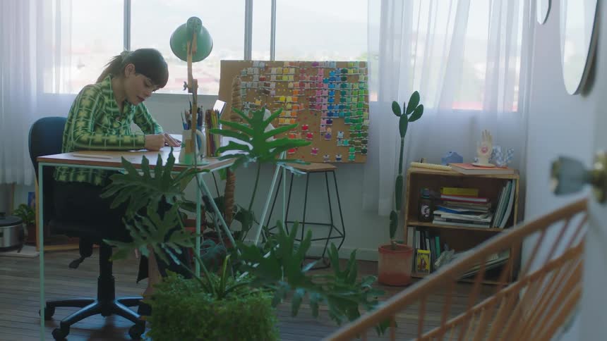 A woman writes at her desk at her home office