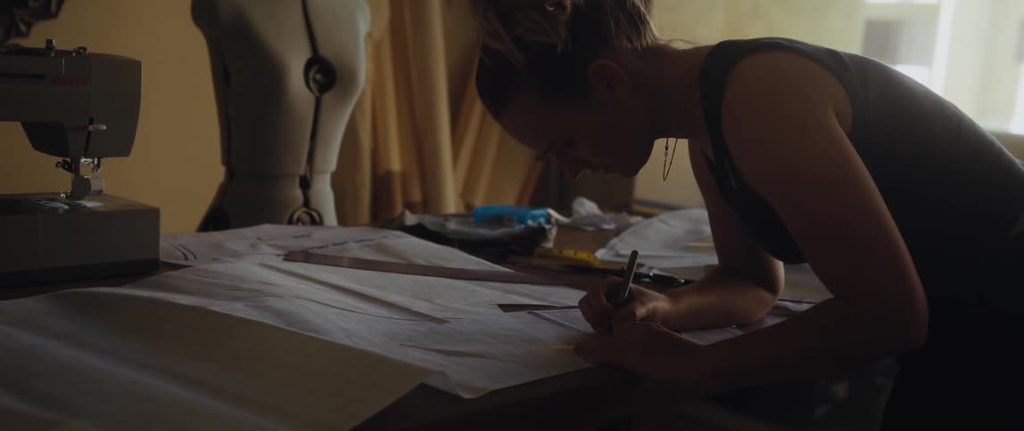 Tailor designs clothing patterns on a sewing workshop