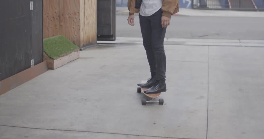 A man is skateboarding on the sidewalk