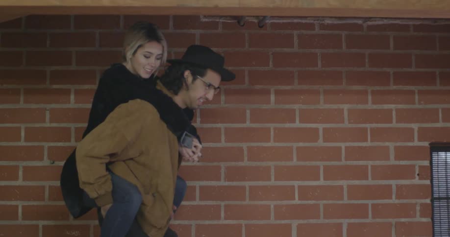 A man walks down steps with a woman on his back
