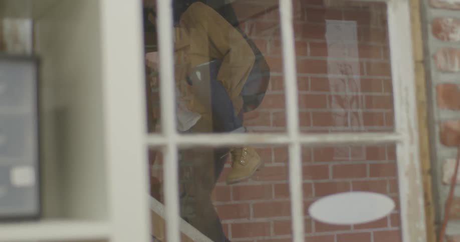 A man climbs steps inside with a woman on his shoulders