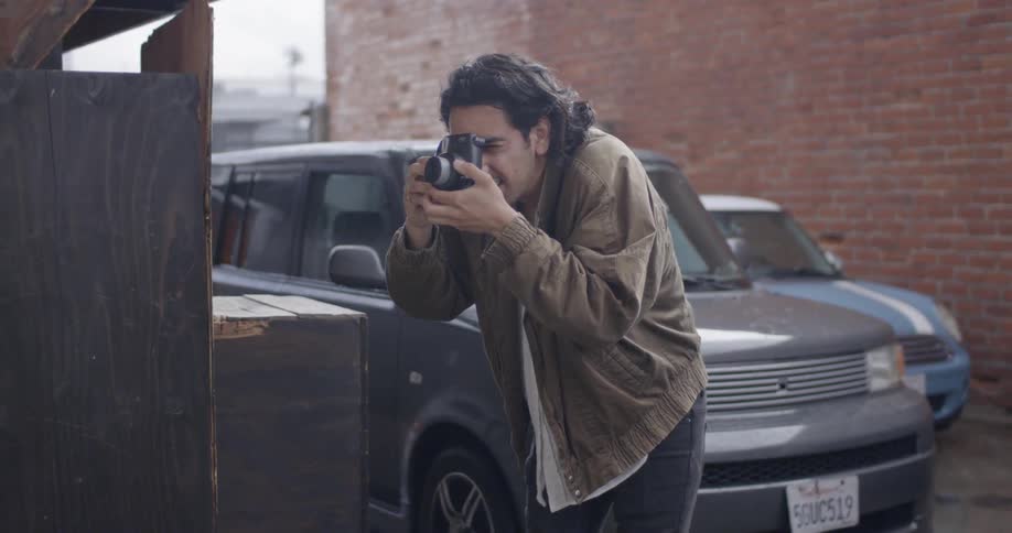 A photographer takes a picture in a city alley