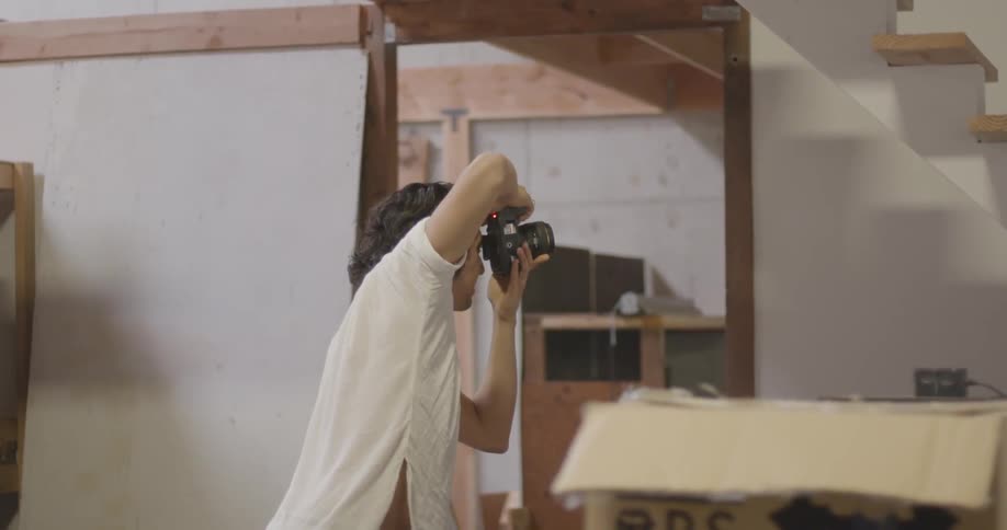 A man takes photographs in a house