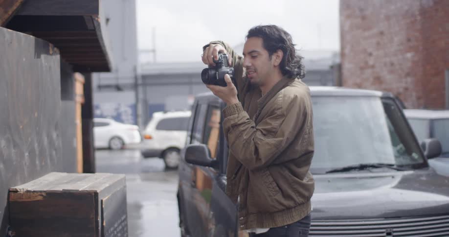 A man standing outside a business takes a photograph
