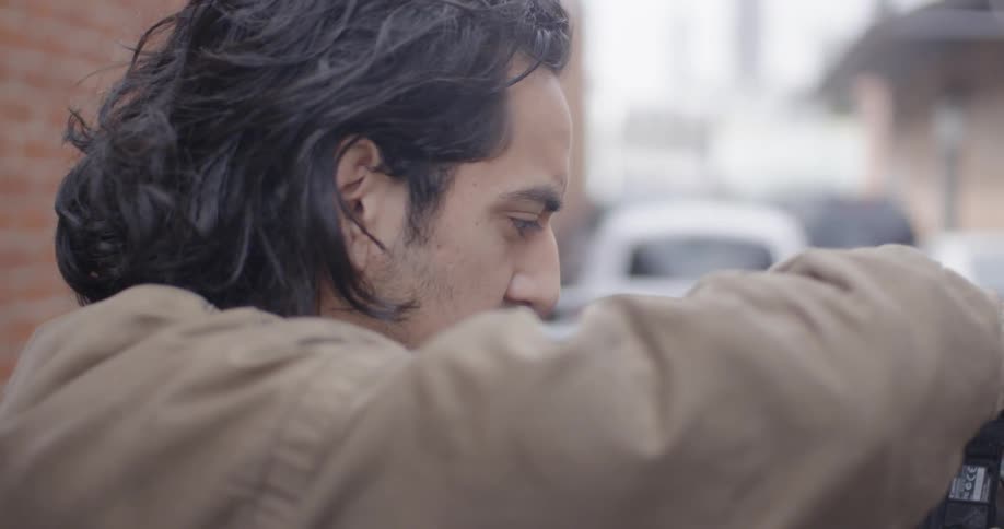 A man stands adjusting his camera