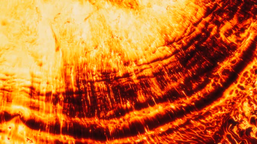 Fiery liquid spills over as a wave crashes