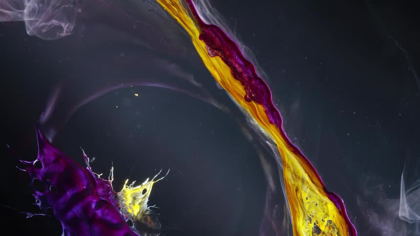 Spreading ripple on translucent gray liquid spread purple yellow and orange floating ink