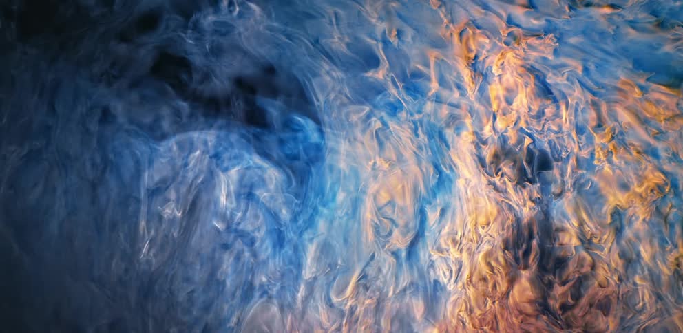Cascade of blue and white smoke flowing down against a black background