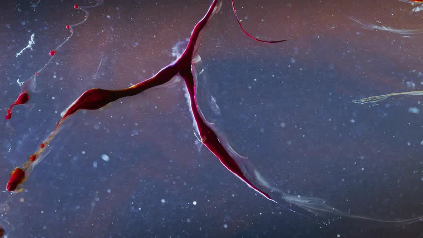Red strands of deep dark glowing red ink flowing against a gray background