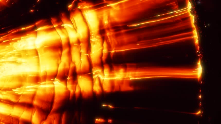 A viscous gold liquid moves across a black background