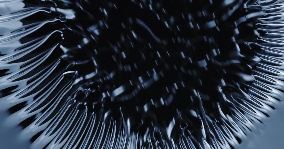 Ring of spikes rise and move over a dark reflective liquid