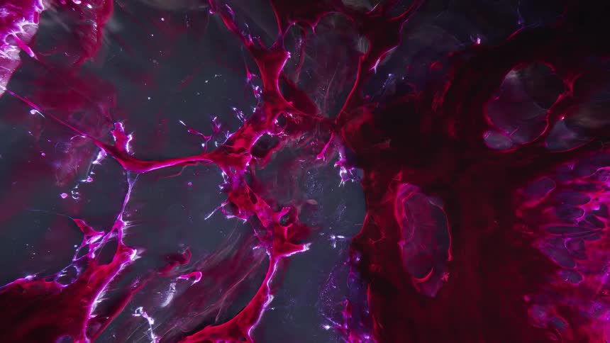 Red strands of deep dark glowing red ink flowing against a dark background