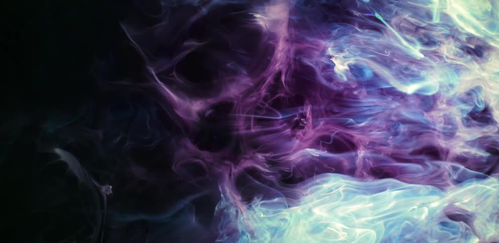 Waves of colorful bright blue and purple smoke floating over a black background