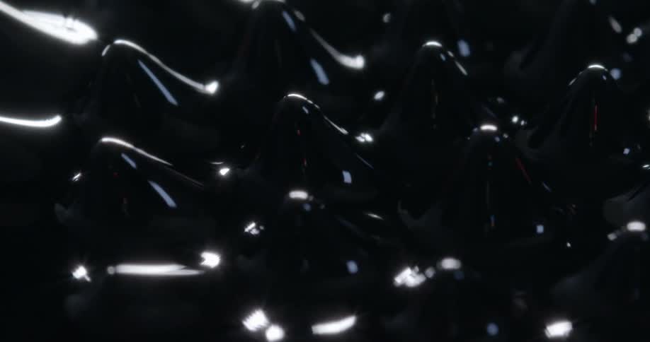 A thick black liquid forms peaks then melts away