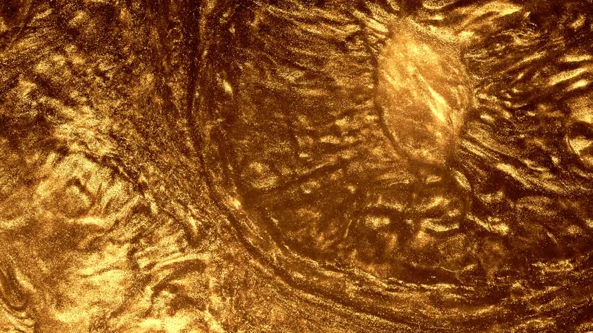 A gold substance moves and rolls into itself