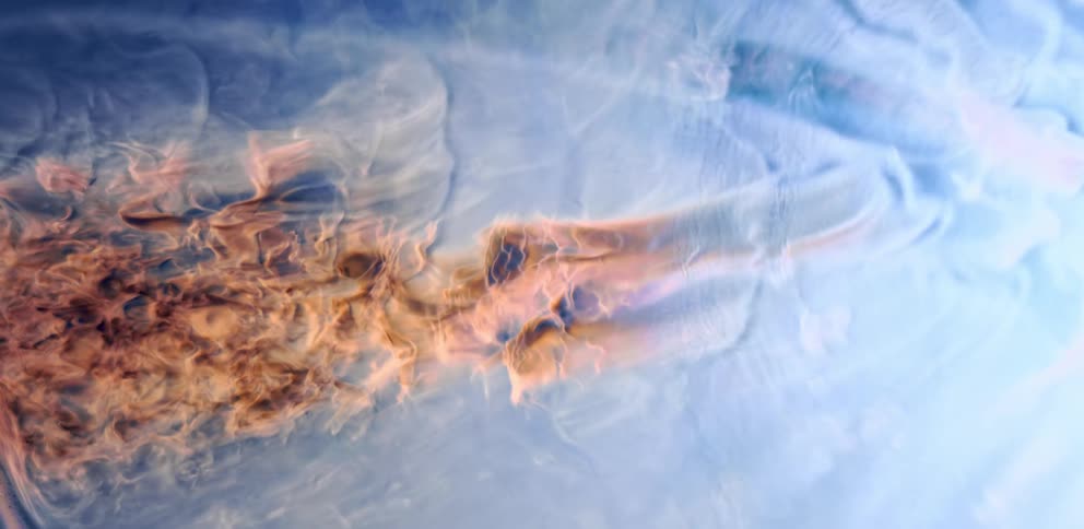 Tightly packed orange smoke moves through blue smoke