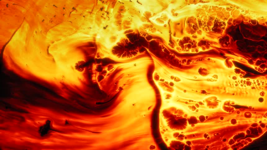 Yellow and red bright flames flow and converge like lava over a black background