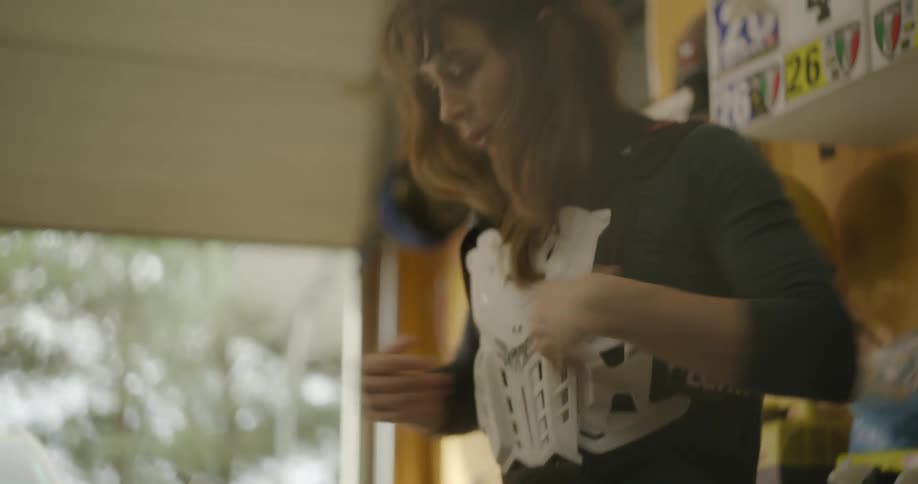 A woman putting on a vest