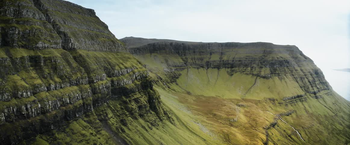An aerial view of grass covered mountains in nature