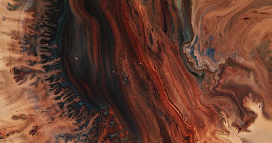 Colorful dark brown and cream liquid ink flowing over a surface