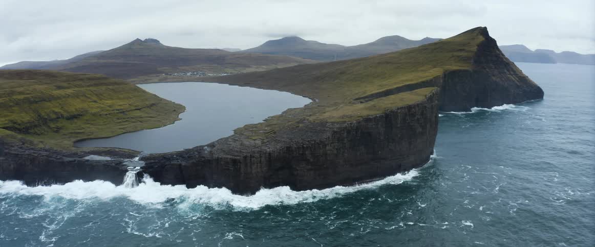 Ocean waves crashing into a steep coastal cliff