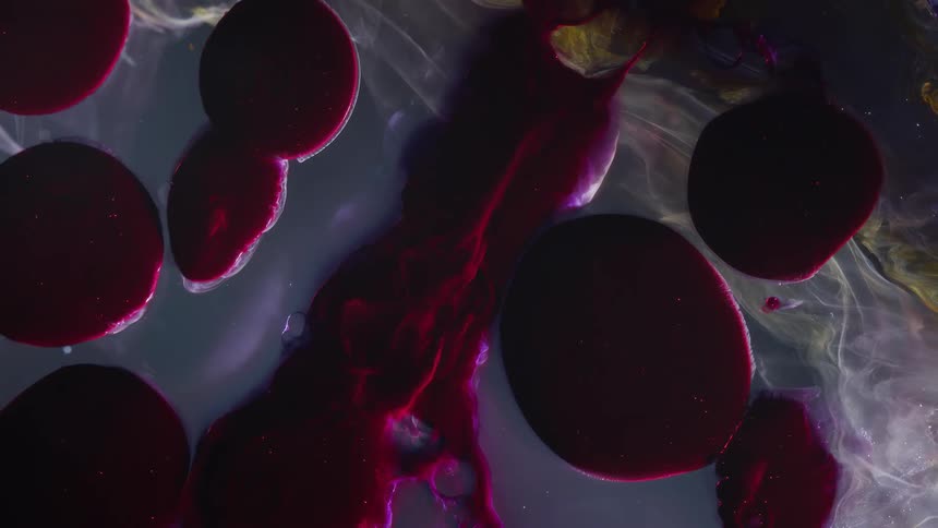 Abstract footage of large red bubbles of liquid dye moving