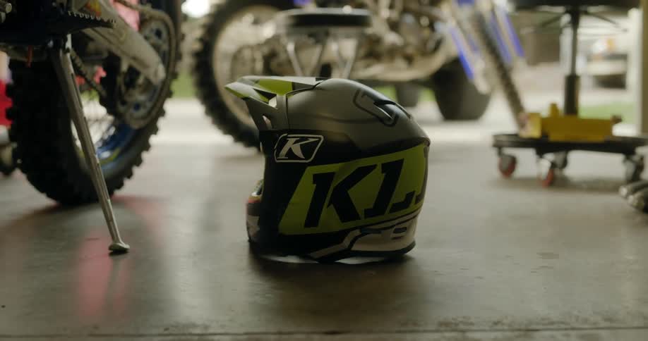 A crash helmet and motorcycles inside a garage