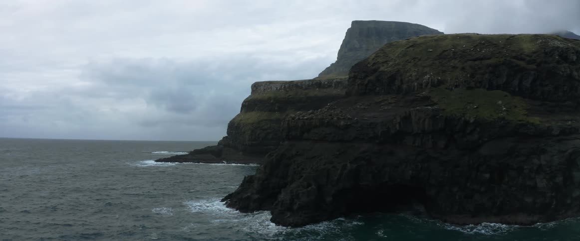 Birds are flying around an island in the ocean