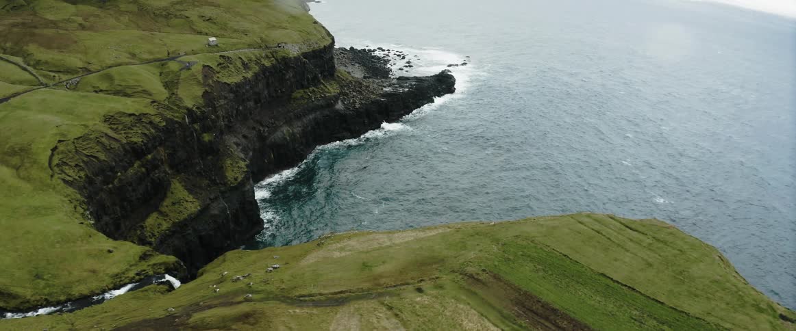 Aerial view of an island on the ocean water is displayed