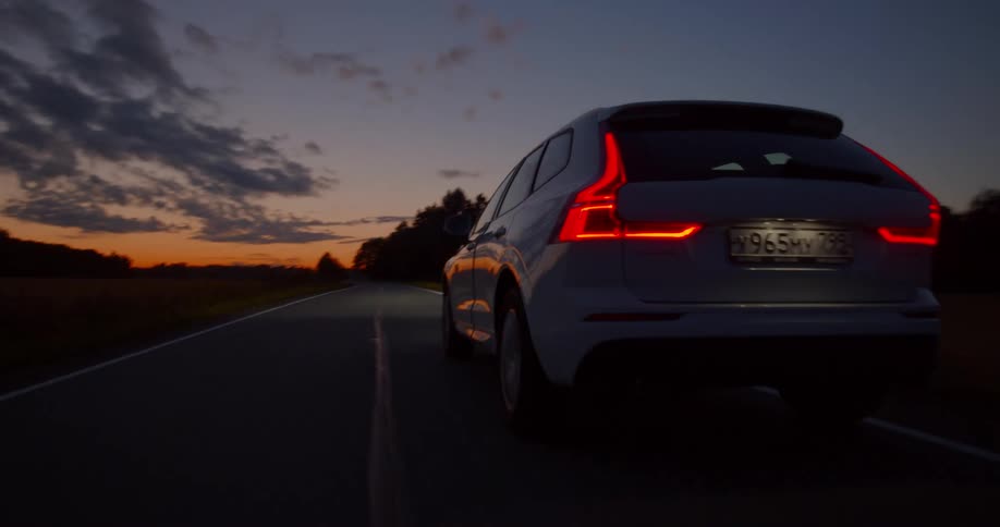 White vehicle driving on road in countryside at sunrise