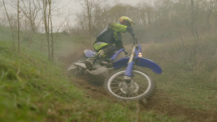 A person rides a motorcycle on a dirt trail