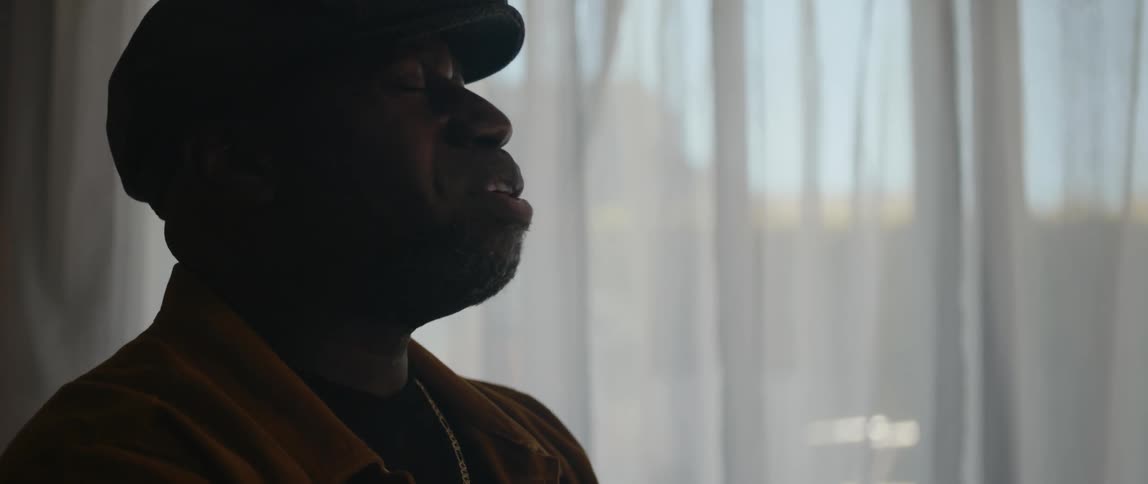 A black man sings at home