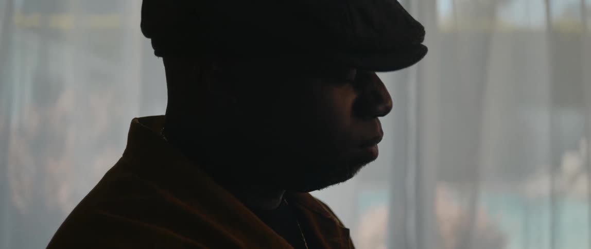A man is sitting indoors near a window