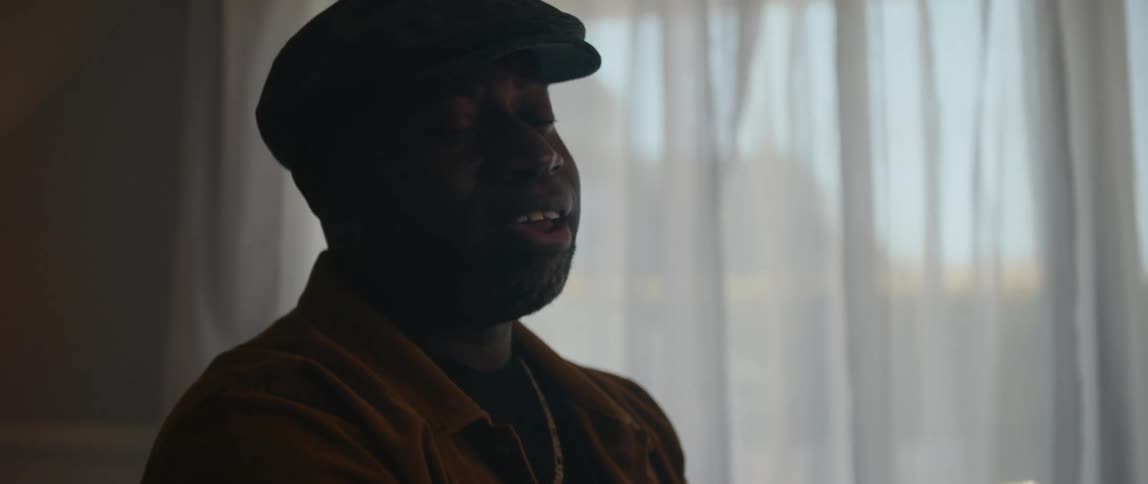 A black man is playing the piano in the living room