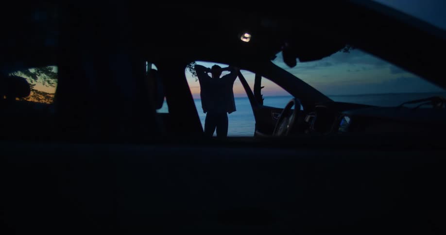 A man is standing outside of his car