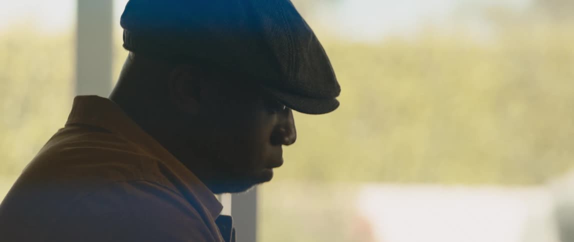 A young black man is sitting in the living room