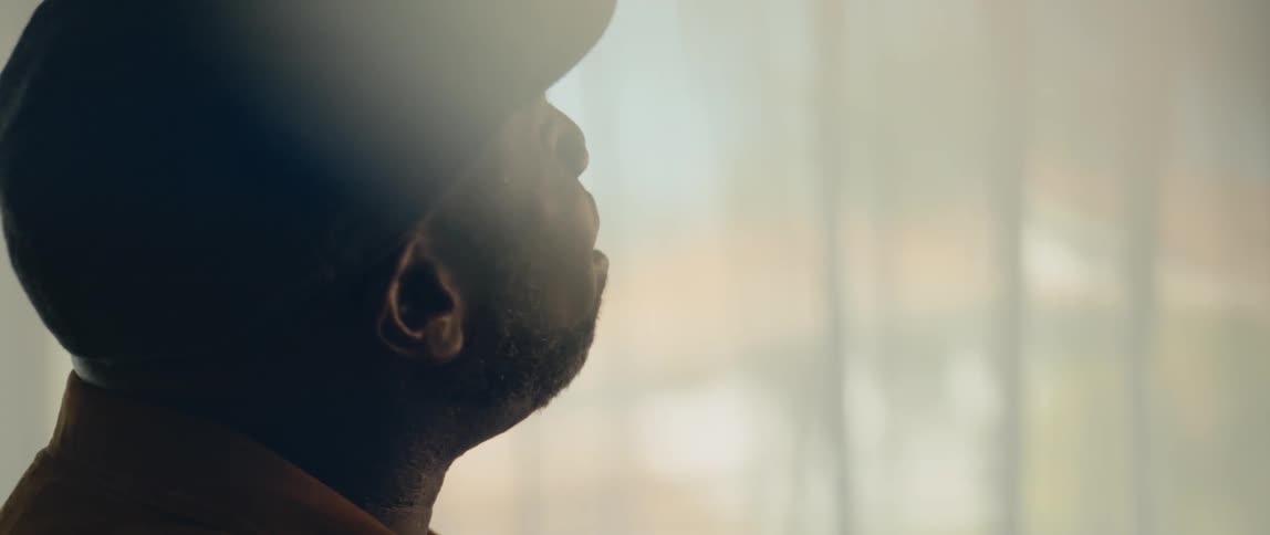 Man sings standing near window as light shines through
