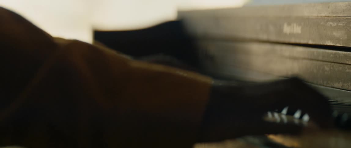 A black man is playing the piano inside his house