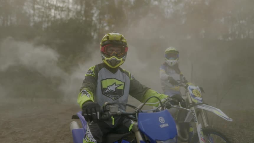 Motorcycle riders posing in the forest surrounded by fog