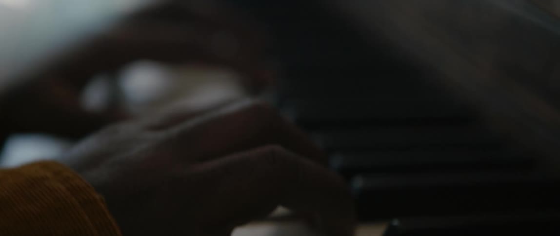 Close up of a mans hands playing the piano