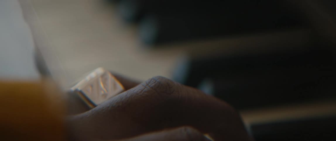 A man wearing a ring is playing piano