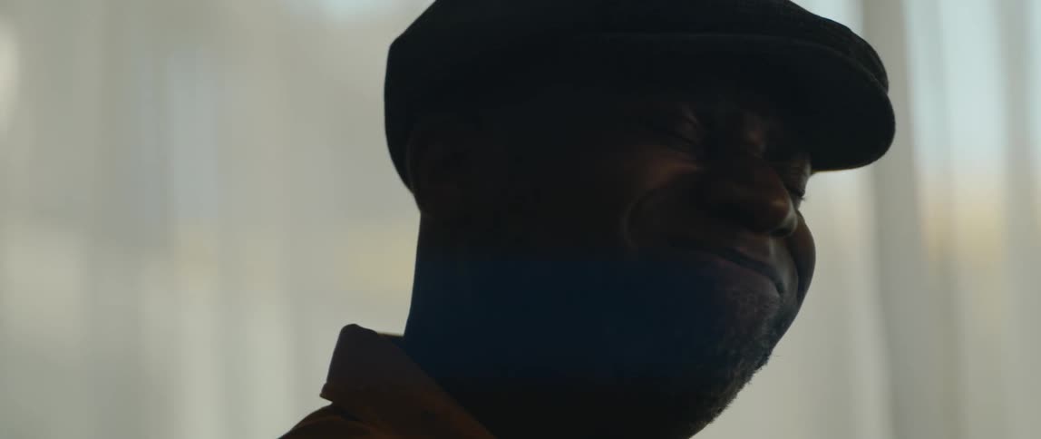 A man is sitting in his room and looks deep in concentration