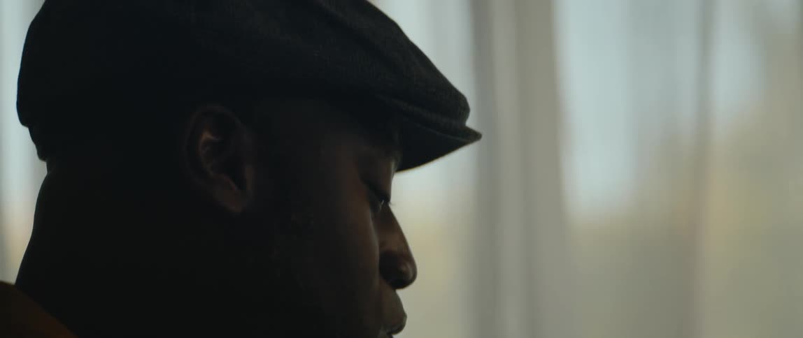 A young black man is singing inside his house