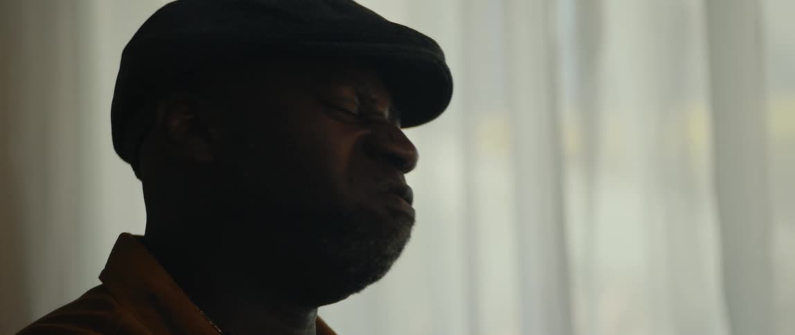 A young black man is singing inside of his house