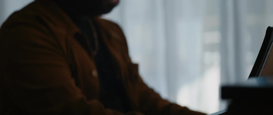 A man is playing a piano instrument indoors